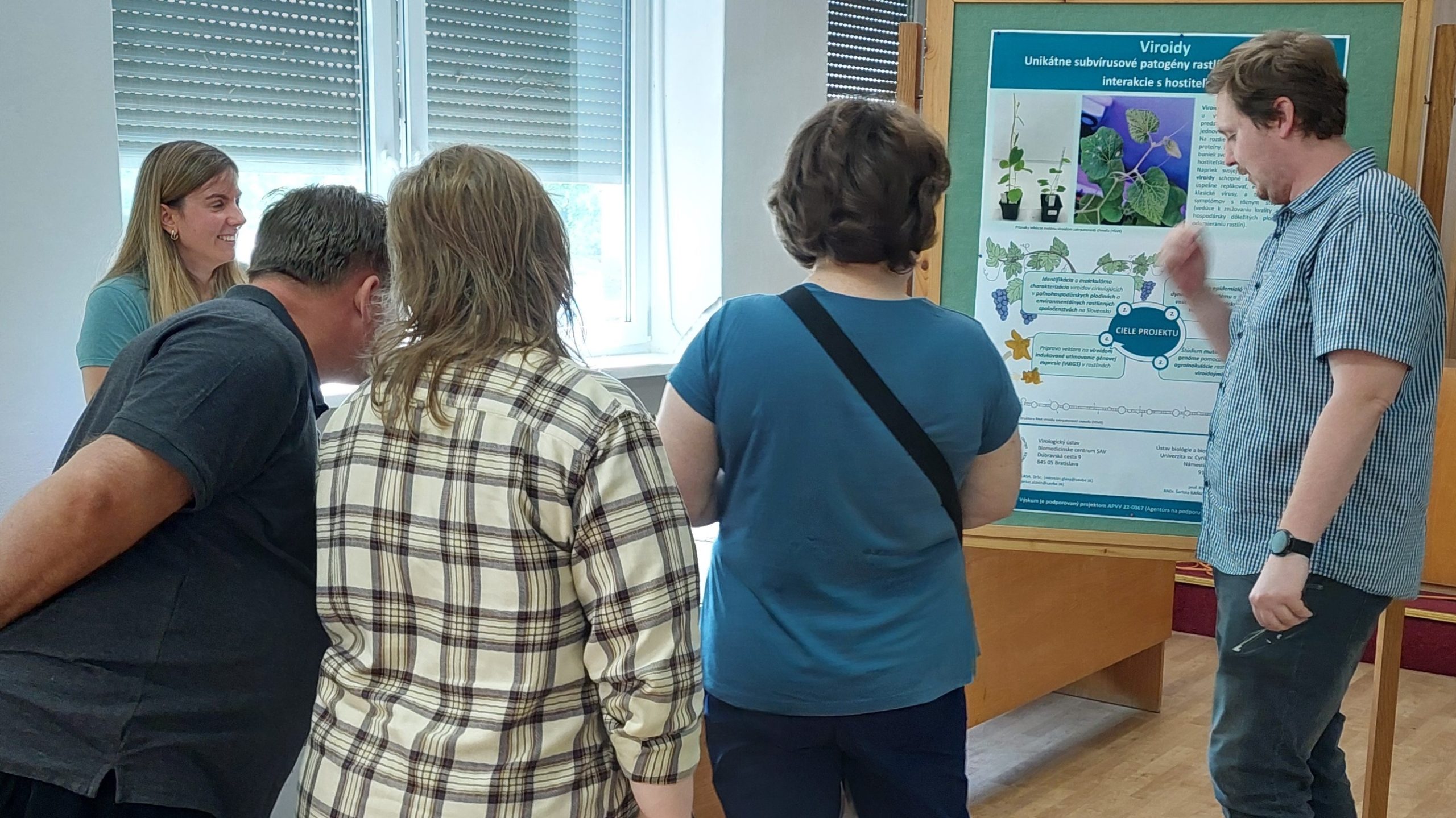 Mladí vedci z BMC SAV predstavujú pred plagátom čiastočné výsledky výskumu o viroidoch na podujatí v Piešťanoch k medzinárodnému Dňu fascinácie rastlinami.