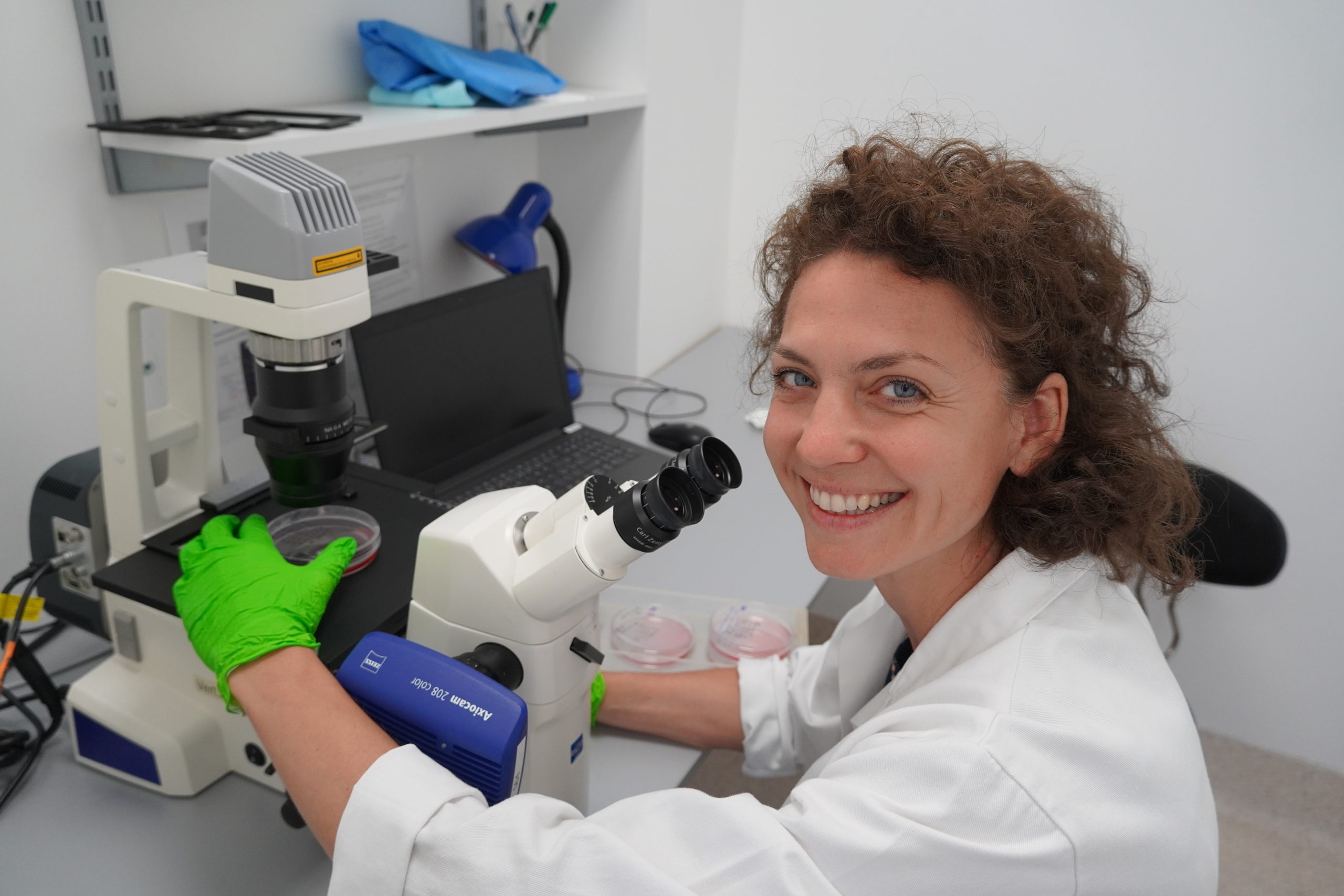 Dr. Marína Cihová, portrét pri práci s mikroskopom v laboratóriu.